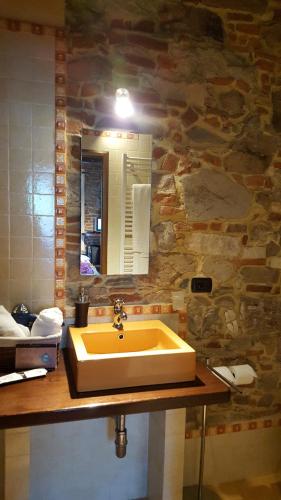 a bathroom with a yellow sink and a mirror at Tangohotel in Lucca