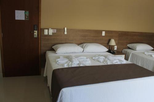 2 letti in camera d'albergo con asciugamani di Avare Plaza Hotel Plus ad Avaré