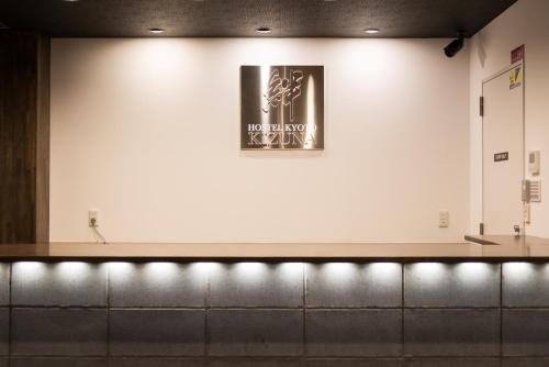 a sign on a wall above a row of benches at KIZUNA HOTEL Gojo Kiyomizu-dera Kamogawa in Kyoto