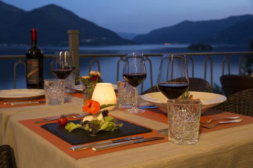 a table with glasses of wine and a plate of food at Hotel Arancio in Ascona