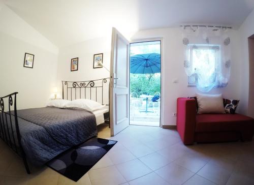 - une chambre avec un lit, une chaise et une porte ouverte dans l'établissement Studio Apartment Adriana, à Poreč