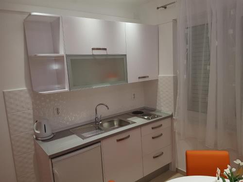 a small kitchen with a sink and a mirror at House Villa Roza in Tučepi