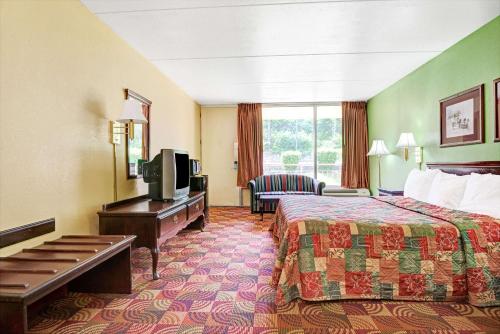 une chambre d'hôtel avec un lit et une télévision dans l'établissement Super 8 by Wyndham Nashville Near Downtown / I-40, à Nashville