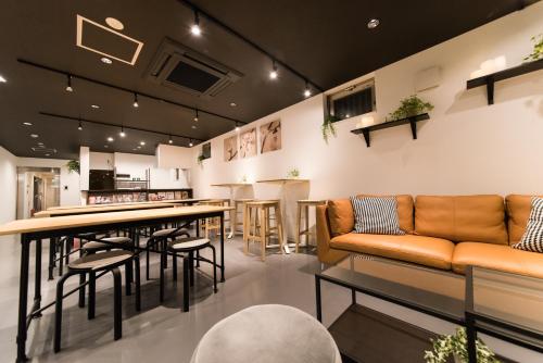 a bar with a couch and a table and chairs at KIZUNA HOTEL Gojo Kiyomizu-dera Kamogawa in Kyoto