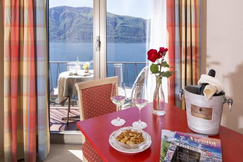 a table with two glasses and a plate of food on it at Hotel Arancio in Ascona