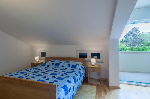 a bedroom with a bed and a large window at Stara Kuća Apartments in Šimuni