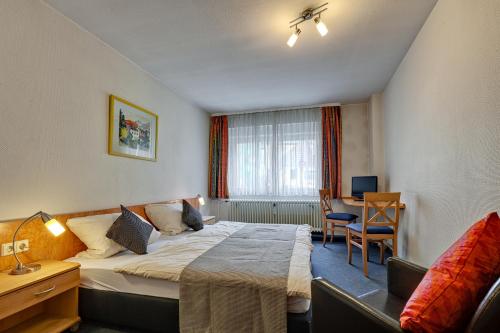 ein Hotelzimmer mit Bett und Schreibtisch in der Unterkunft Hotel Alte Post in Calw