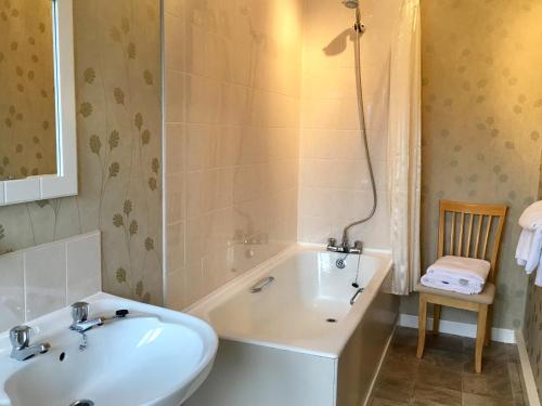 a bathroom with a bath tub and a sink at Lochearnhead Hotel in Lochearnhead