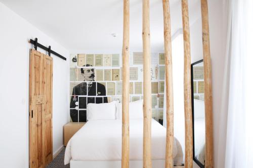 a bedroom with a white bed with wooden posts at Sapientia Boutique Hotel in Coimbra
