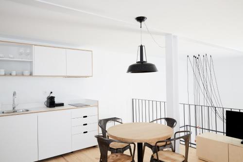 a kitchen and dining room with a table and chairs at Sapientia Boutique Hotel in Coimbra