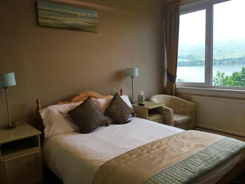 Lochearnhead Hotel في لاكرنهيد: غرفه فندقيه بسرير ونافذه
