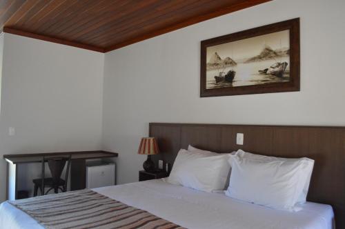 a bedroom with a bed and a picture on the wall at Pousada Terê Parque in Teresópolis
