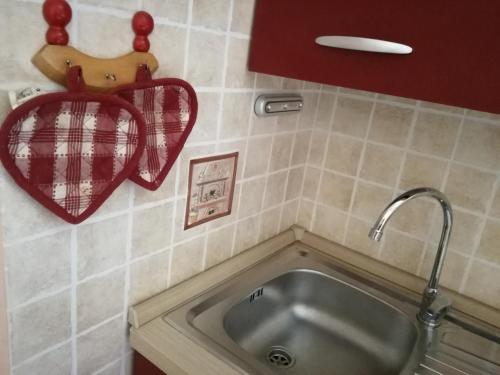 Panorama Apartment في Pognana Lario: حوض في مطبخ مع قلب على الحائط
