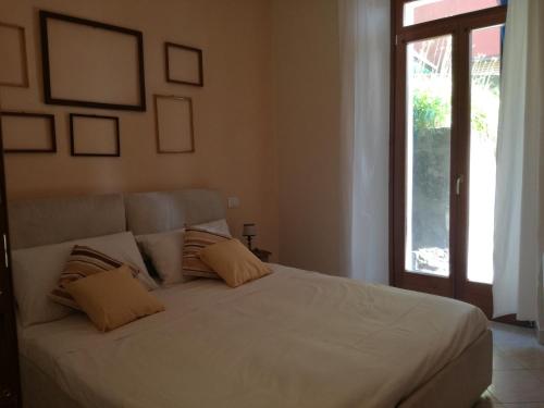 Panorama Apartment في Pognana Lario: غرفة نوم مع سرير أبيض كبير مع نافذة