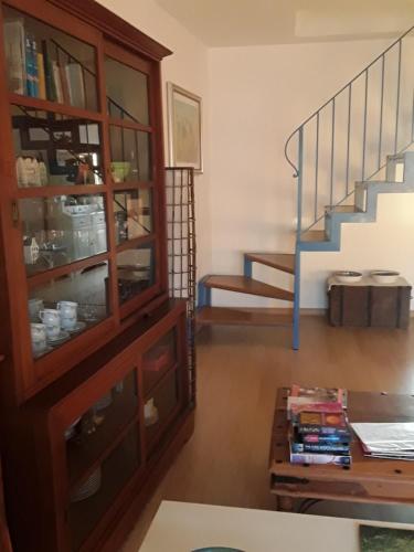 a living room with a book shelf and a staircase at B&B Lloc D'Or in Alghero