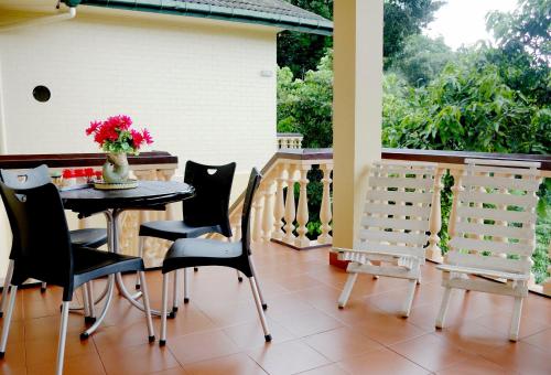 a dining room with a table and chairs on a porch at Evergreen in Kandy