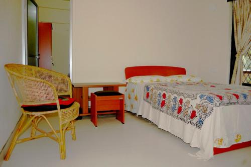 sypialnia z łóżkiem, 2 krzesłami i stołem w obiekcie Evergreen w mieście Kandy