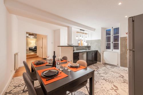 une salle à manger avec une table et une cuisine dans l'établissement Cité Chic, à Carcassonne