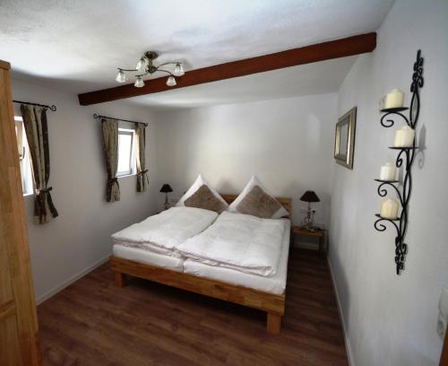 a bedroom with a white bed and two windows at Gästehaus am Plönlein in Rothenburg ob der Tauber