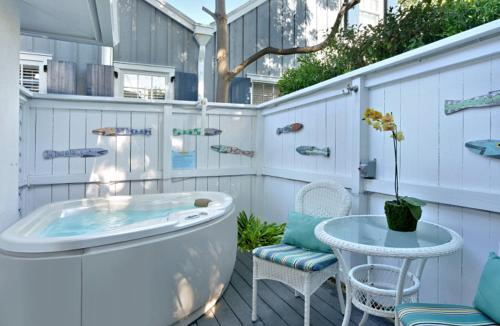 a tub on a deck with a table and chairs at Center Court-Boutique Old Town Lodging in Key West