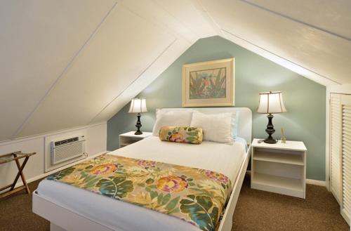 a bedroom with a bed and two night stands with lamps at Center Court-Boutique Old Town Lodging in Key West