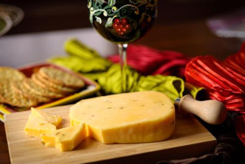 a block of cheese on a cutting board with a glass of wine at Stewart Inn in Wausau