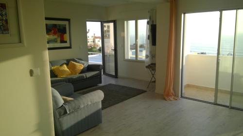 Una sala de estar con un sofá y vista al mar. en Ericeira penthouse with total sea view, en Ericeira