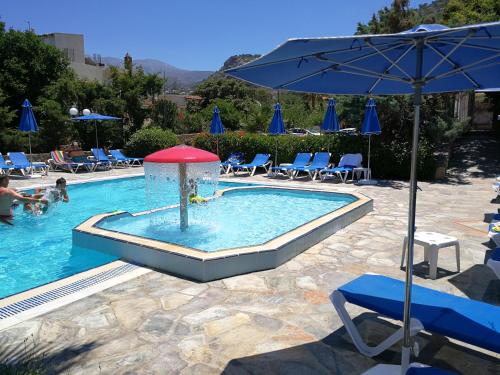 una piscina con fontana con sedie e ombrellone di Camelot Royal Beds by Estia a Mália