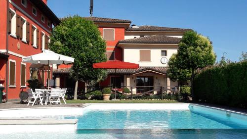 a swimming pool in front of a house at Hotel Tre Torri in Medolla