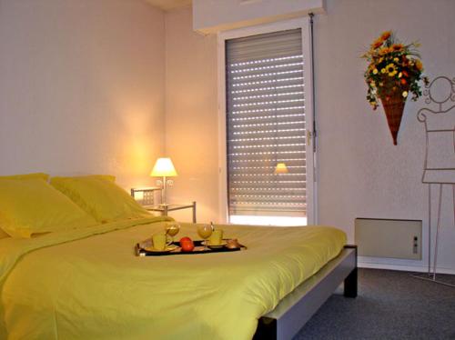 Un dormitorio con una cama con una bandeja de fruta. en zizouk Bordeaux, en Mérignac