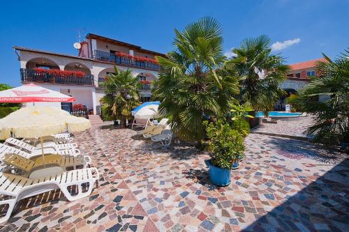 a patio with chairs and umbrellas and a building at Apartments Paradis in Rovinj