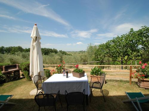 a table with a white table cloth and a umbrella at Il Poderino in Monteriggioni