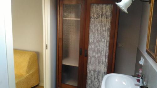 a bathroom with a glass door next to a sink at B&B Casa Lulù in Brembate