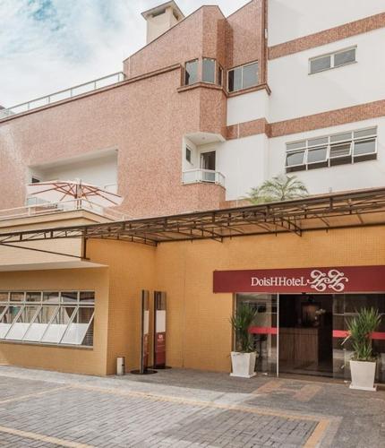 a building with a sign in front of it at Hotel Dois H in Joinville