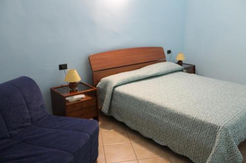 1 dormitorio con 1 cama y 1 silla azul en Rose Apartment, en Crotone