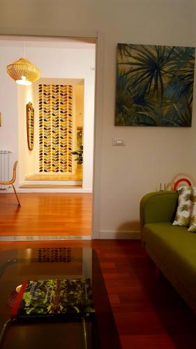 a living room with a green couch and a glass table at Napoli Tree - Lungomare in Naples