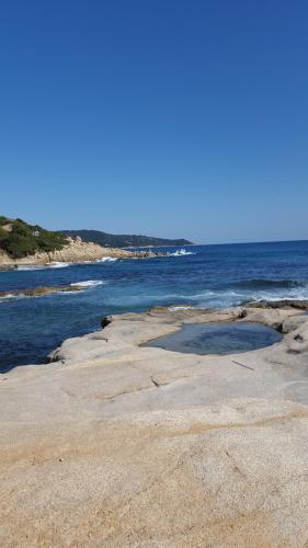 a beach with a large crater in the middle of the water at Mas de la Petite Jeanne in Grimaud