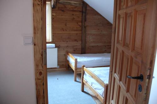 an attic room with two beds and a door at Siedlisko Gizewo in Gizewo