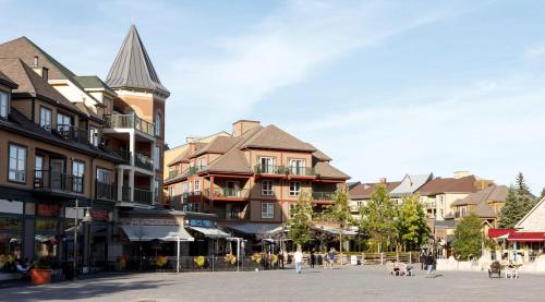 a city street with buildings and people walking dogs at Mountain Side Condo Loft at The Blue Mountains in Blue Mountains