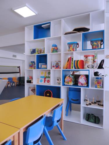 a classroom with a yellow table and blue chairs at Hotel Cesar Augustus in Cambrils
