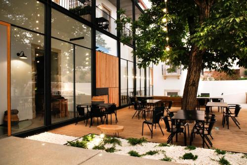 a patio with tables and chairs and a tree at Sapientia Boutique Hotel in Coimbra
