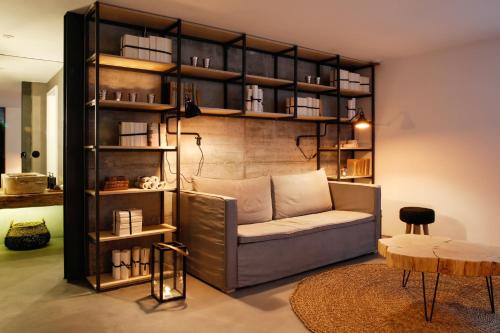 a living room with a couch and a book shelf at Sapientia Boutique Hotel in Coimbra