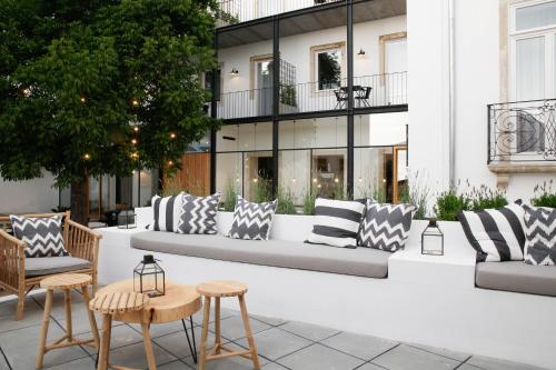 a patio with couches and chairs and a building at Sapientia Boutique Hotel in Coimbra