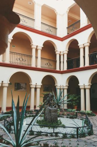 a building with arches and plants in the courtyard at Hotel Los Monteros in Ciudad Victoria