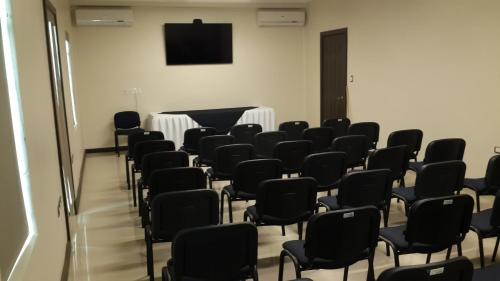 an empty room with chairs and a flat screen tv at Hotel Los Monteros in Ciudad Victoria