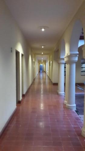 an empty hallway in a building with white columns at Hotel Los Monteros in Ciudad Victoria