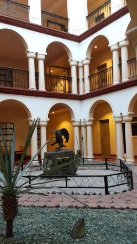 a building with a statue in the middle of a courtyard at Hotel Los Monteros in Ciudad Victoria
