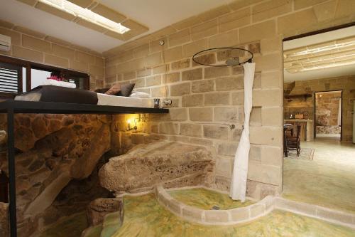 a room with a bed and a stone wall at Villa Punta San Nicola in Favignana