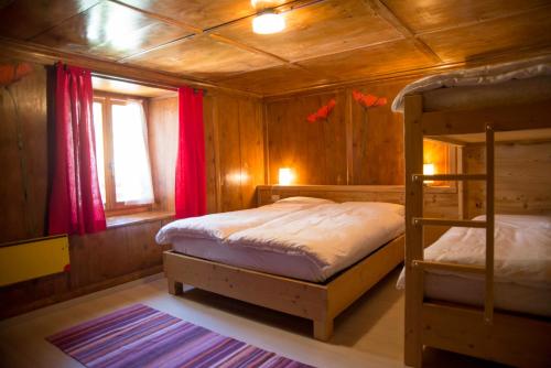 a bedroom with two bunk beds and a window at Hotel Vittoria - Ca' De La Montagna in Montespluga