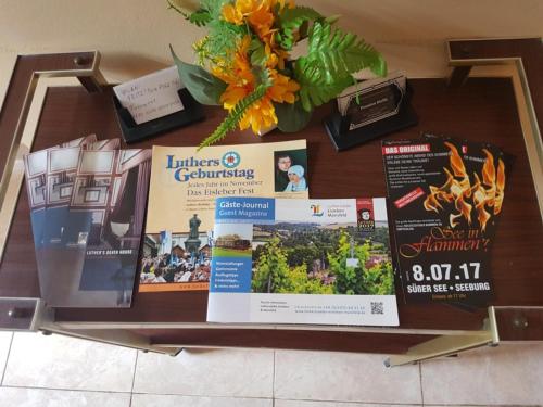 a table with a bunch of brochures on it at Pension STELLA in Lutherstadt Eisleben